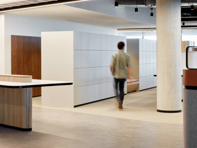 Man walking past sleek white laminate agile workplace lockers