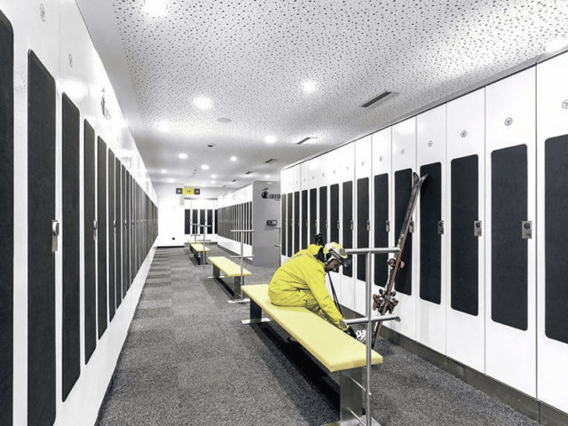 Skiier getting skis ready by lockers
